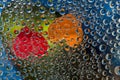 Multi colored drops of water are located on a blue-green background with a red and orange silhouettes of the hearts. Royalty Free Stock Photo