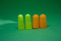 Multi-colored ear plugs on a green background. Close-up. Selective focus Royalty Free Stock Photo