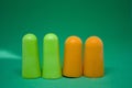 Multi-colored ear plugs on a green background. Close-up. Selective focus Royalty Free Stock Photo