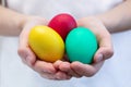 Multi-colored eggs in children`s hands. Yellow, red, green eggs in the hands of a boy Royalty Free Stock Photo