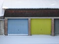 Multi colored garage door and snow in front of a garages