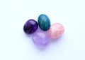 Multi-colored gemstones, cut tumbling stones. Amethyst, rose quartz, apatite on a white background