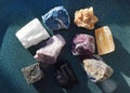 Multi-colored gemstones, minerals on a blue ceramic plate. Rose quartz, turquoise, labradorite, sodalite, fluorite, red gypsum, Royalty Free Stock Photo