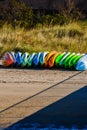 Multi-colored Kayaks Stored on the Sand by the Pier
