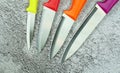 Multi-colored kitchen knives: red, burgundy, orange, yellow. Modern knives for domestic use. Kitchen tool.