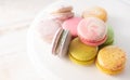 Multi-colored macarons close up on wood background with soft lights. French dessert for breakfast in the morning light