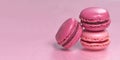 Multi-colored macaroons on a pink background.