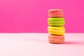 Multi-colored macaroons stand in a pile on a pink table Royalty Free Stock Photo