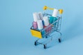 Multi-colored nail polish stand in a shopping cart on a blue background Royalty Free Stock Photo