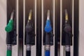 Multi colored nozzles of fuel pumps with hoses at a gas station close up. Background Royalty Free Stock Photo