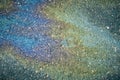 A multi-colored oil stain creates a mesmerizing iridescent pattern on the wet asphalt surface. Royalty Free Stock Photo