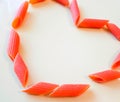 Multi-colored pasta in plates in the form of a heart on a white table. beautiful colored pasta lie in a plate of heart shape, Royalty Free Stock Photo