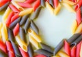 Multi-colored pasta in plates in the form of a heart on a white table. beautiful colored pasta lie in a plate of heart shape, Royalty Free Stock Photo