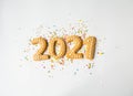 Multi colored pastry sugar topping and gingerbread in the form of numbers 2021 on a white background. 2021 new year ginger cookies