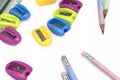 Multi-colored pencil sharpeners and multi-colored pencils on a white table Royalty Free Stock Photo