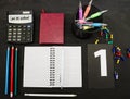 Multi-colored pens, notebook, book and pencils on a black table. Education concept. View from above. Royalty Free Stock Photo