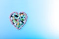 Multi-colored pills in the shape of heart on blue gradient background. Daily Vitamins dose. Heart shape made of tablets Royalty Free Stock Photo