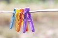 Multi colored plastic clothes clips on the wire on nature background. Royalty Free Stock Photo