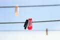 Multi-colored plastic clothespins hanging on the clothesline on