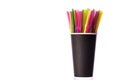 Multi-colored plastic straws in black paper glass isolated on white background Royalty Free Stock Photo