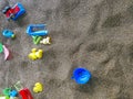 Multi-colored plastic toys in the sand. Children`s toys for games in the sand and on the beach. Bucket, spade and rake. Royalty Free Stock Photo