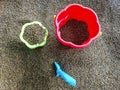 Multi-colored plastic toys in the sand. Children`s toys for games in the sand and on the beach. Bucket, spade and rake. Royalty Free Stock Photo