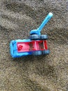 Multi-colored plastic toys in the sand. Children`s toys for games in the sand and on the beach. Bucket, spade and rake. Royalty Free Stock Photo