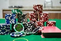 Poker chips with playing cards on a green table