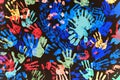 Multi-colored prints of hands smeared with paint on a black wall Royalty Free Stock Photo