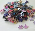 Multi colored puzzle pieces on a white surface Royalty Free Stock Photo