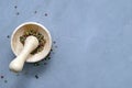 Multi-colored red green black peppercorns in a wooden mortar with pestle and scattered around on a ultimate gray Royalty Free Stock Photo