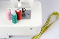 multi-colored sewing reels with threads stand against the background of a sewing machine. taken in close-up, with a place for text Royalty Free Stock Photo