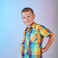 In a multi-colored shirt, a child poses on a gradient colored background Royalty Free Stock Photo
