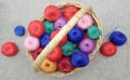 multi-colored, skeins of thread in a wicker basket and scattered near it
