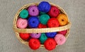 multi-colored skeins of thread in a wicker basket, top view.