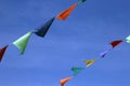 Multi colored small triangular fair flags on a rope on a blue sk Royalty Free Stock Photo