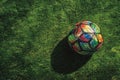 A multi-colored soccer ball casts a soft shadow on the textured grass during a sunset, evoking the joy of sports Royalty Free Stock Photo