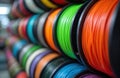 Multi-colored spools of 3D printer filament. Various colorful plastic threads for additive manufacturing. Rows of plastic coils Royalty Free Stock Photo