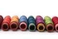 Multi-colored spools of thread stacked in a row Royalty Free Stock Photo