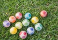 Multi-colored spotted balls are laid out on green grass. Soft daylight Royalty Free Stock Photo