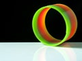 Multi-colored spring, developing toy on white steel and black background Royalty Free Stock Photo
