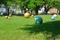 Multi-colored stone spheres lie on a lawn. Braniewo, Poland Royalty Free Stock Photo