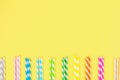 Multi-colored straw paper tubes on a bright yellow pastel background. Top view, copy space. Royalty Free Stock Photo
