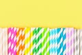 Multi-colored straw paper tubes on a bright yellow pastel background. Top view, copy space. Royalty Free Stock Photo