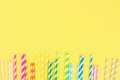 Multi-colored straw paper tubes on a bright yellow pastel background. Top view, copy space. Royalty Free Stock Photo