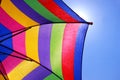 Multi colored striped parasol, blue sky