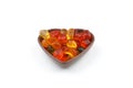 multi-colored sweet candies in heart shaped bowl on white background, top view. Space for text Royalty Free Stock Photo