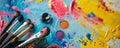 A multi-colored table with makeup products and brushes arranged in an artistic manner. The vibrant Royalty Free Stock Photo