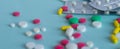 Multi-colored tablets of different shapes and colors. Placer pills and a stack of blisters. Web banner. Medical concept