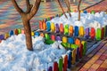 Multi-colored tiles and a small wooden fence under the trees in the park on the playground Royalty Free Stock Photo